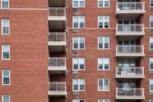 apartment building exterior with brick, windows and balconies